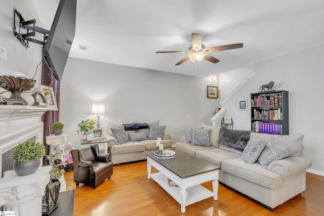 living room with light wood-type flooring and ceiling fan