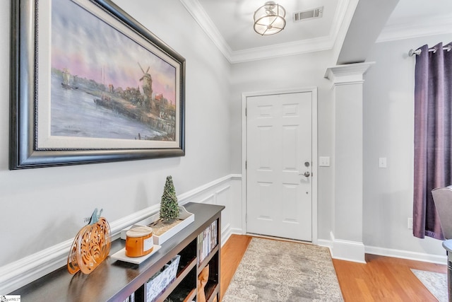 entryway with crown molding and light hardwood / wood-style floors