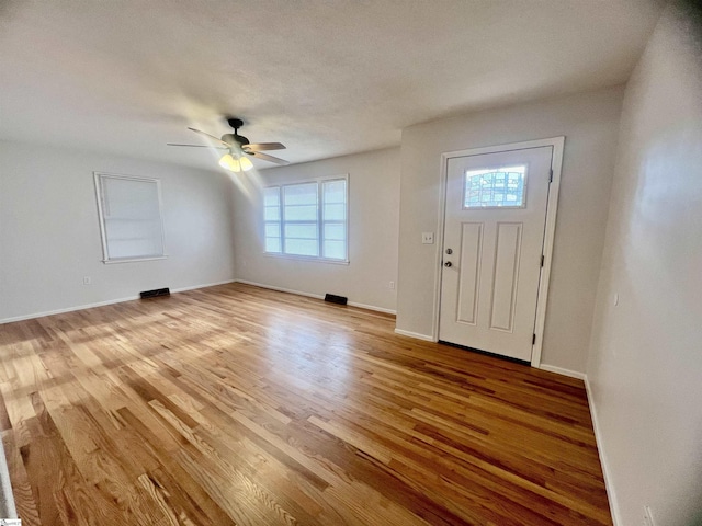 foyer entrance with ceiling fan and light wood-type flooring