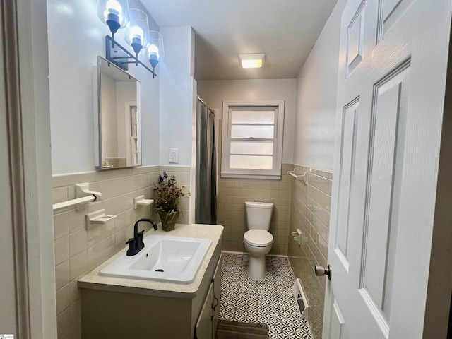 bathroom with tile patterned floors, vanity, toilet, and tile walls