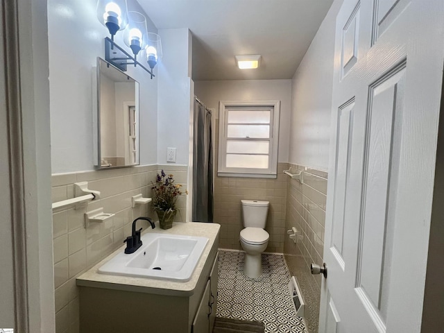 bathroom with tile patterned flooring, vanity, tile walls, and toilet