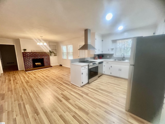 kitchen featuring sink, wall chimney exhaust hood, light hardwood / wood-style floors, white cabinetry, and stainless steel appliances