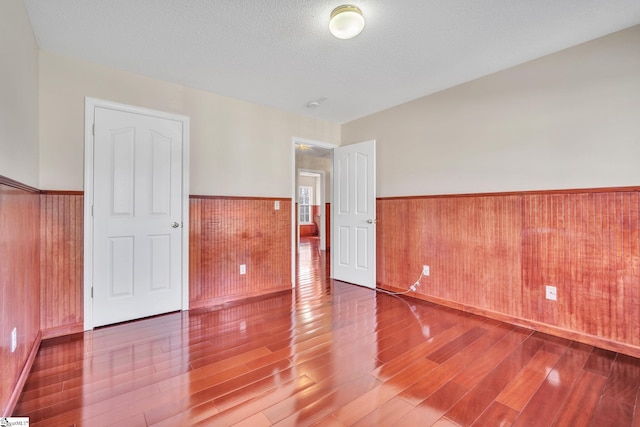 spare room with hardwood / wood-style floors and a textured ceiling