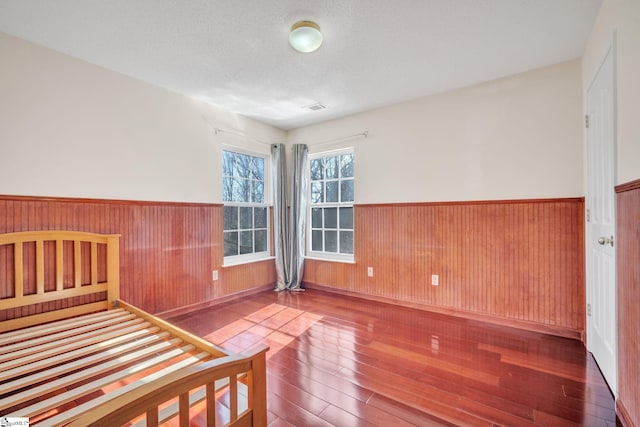 unfurnished bedroom featuring a textured ceiling and hardwood / wood-style flooring