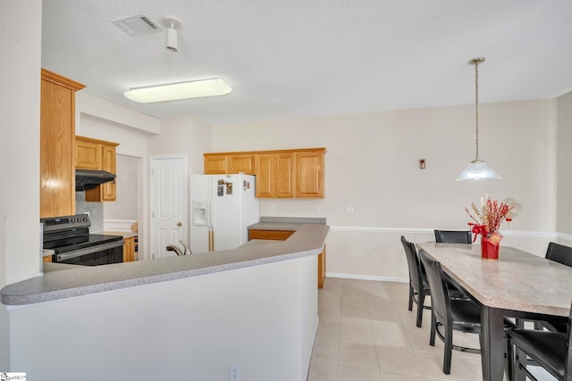 kitchen featuring kitchen peninsula, white fridge with ice dispenser, stainless steel range with electric cooktop, and light tile patterned floors