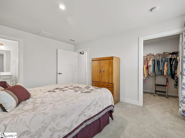 carpeted bedroom with a spacious closet and a closet