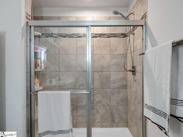 bathroom with a shower with door