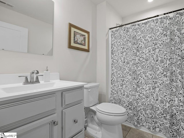 bathroom with tile patterned flooring, vanity, and toilet