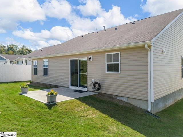 back of house featuring a patio area and a lawn