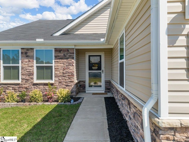 view of exterior entry with a lawn