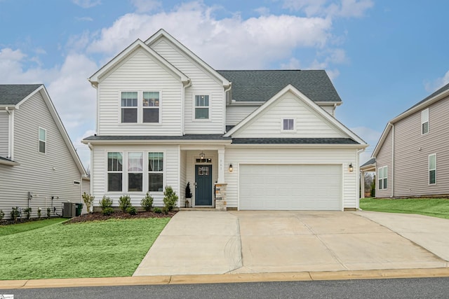 view of front of home with central air condition unit, a front lawn, and a garage