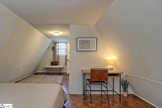 bedroom featuring dark parquet flooring and lofted ceiling