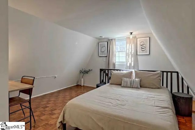 bedroom featuring dark parquet floors and vaulted ceiling