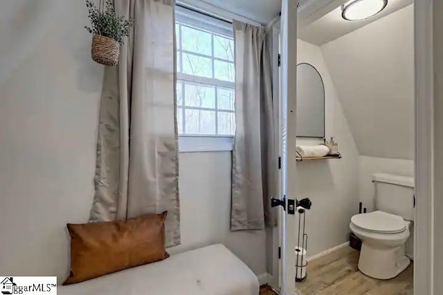 bathroom with hardwood / wood-style floors, toilet, and vaulted ceiling