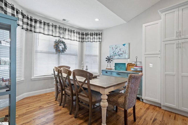 dining space featuring light hardwood / wood-style flooring and vaulted ceiling