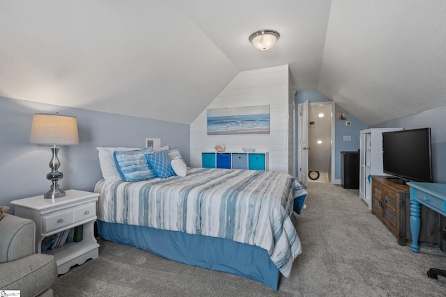 bedroom with a textured ceiling, light colored carpet, and lofted ceiling