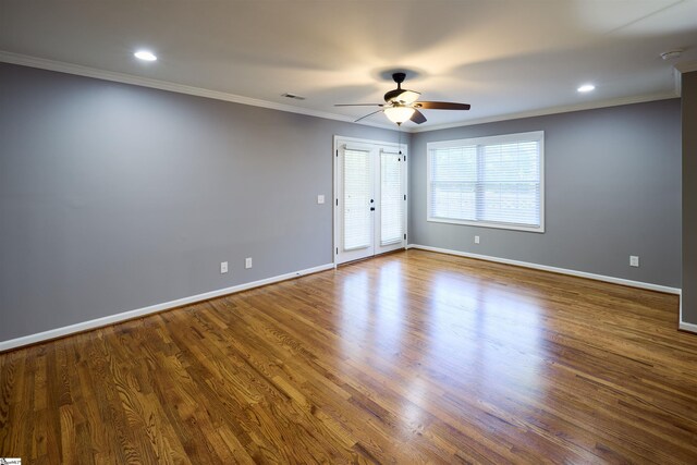 empty room featuring french doors, hardwood / wood-style flooring, and ornamental molding