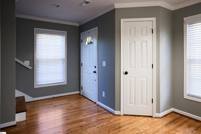 foyer entrance featuring hardwood / wood-style floors and crown molding