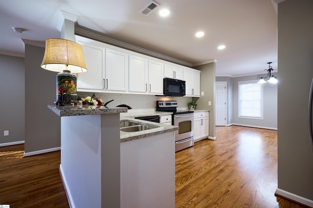 kitchen with white cabinets, electric stove, hanging light fixtures, a notable chandelier, and kitchen peninsula