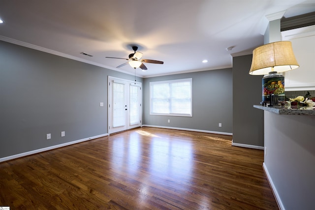 spare room with dark wood-type flooring, ceiling fan, and ornamental molding