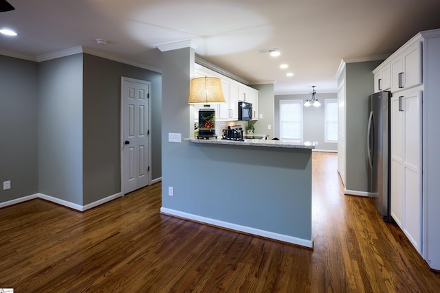 kitchen with white cabinetry, light stone counters, kitchen peninsula, stainless steel fridge, and crown molding