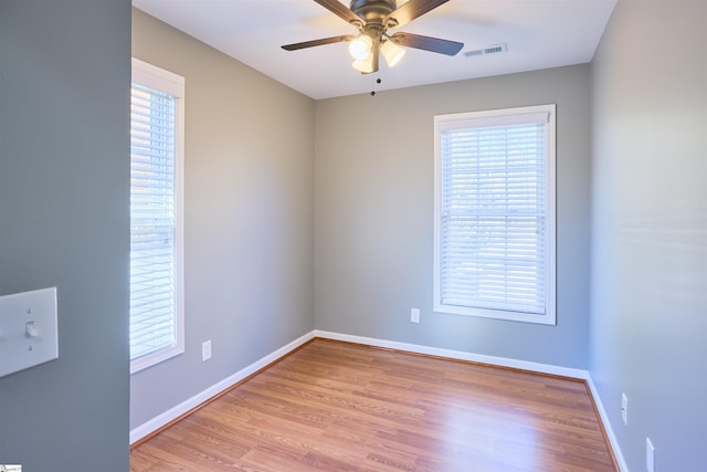 spare room featuring a wealth of natural light, ceiling fan, and light hardwood / wood-style floors