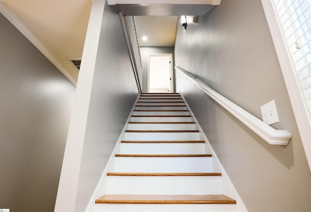 staircase featuring crown molding