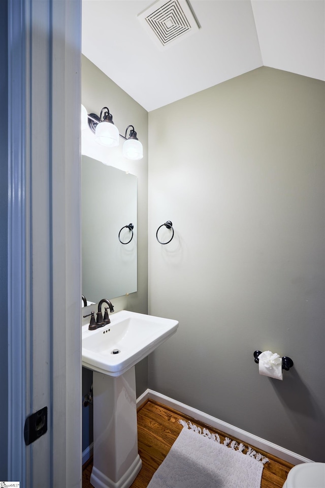 bathroom with hardwood / wood-style flooring and lofted ceiling