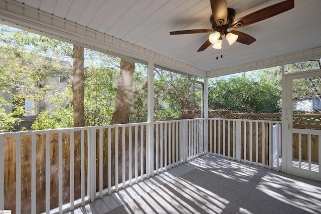 unfurnished sunroom featuring ceiling fan and a wealth of natural light