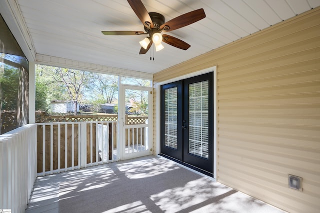 unfurnished sunroom featuring ceiling fan and french doors