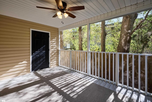 unfurnished sunroom featuring ceiling fan