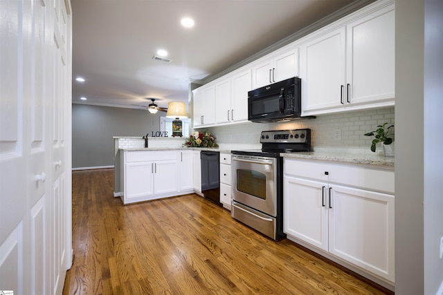 kitchen with backsplash, kitchen peninsula, wood-type flooring, white cabinets, and black appliances