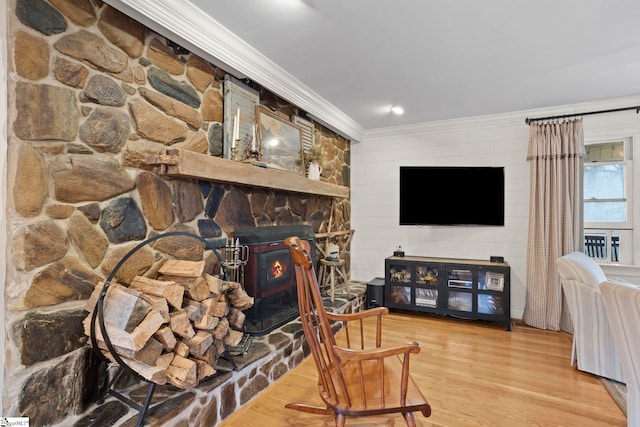 living room with hardwood / wood-style flooring, a wood stove, and crown molding