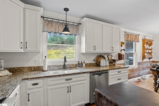 kitchen with stainless steel dishwasher, sink, wood-type flooring, white cabinets, and hanging light fixtures