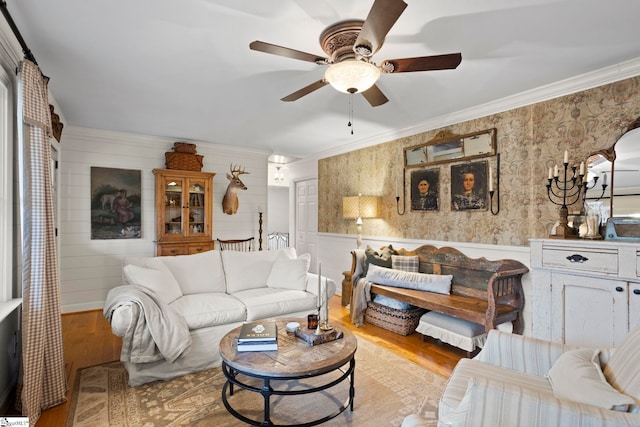 living room with light wood-type flooring, ceiling fan, and crown molding