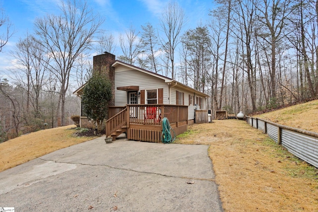 view of property exterior featuring a lawn and a wooden deck