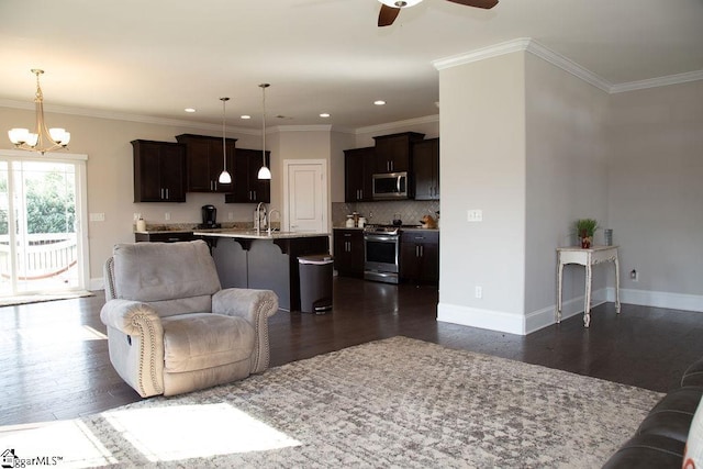 living room featuring sink, ceiling fan with notable chandelier, dark hardwood / wood-style flooring, and crown molding