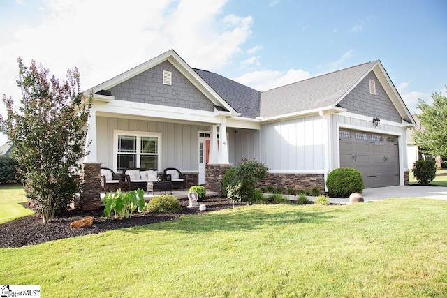 craftsman-style home featuring a garage, covered porch, and a front yard