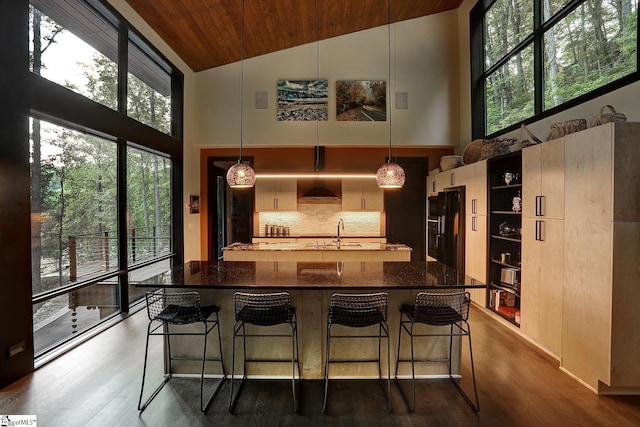 kitchen with dark stone countertops, high vaulted ceiling, pendant lighting, and wood ceiling