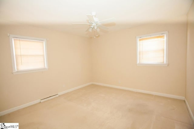 carpeted spare room with ceiling fan and a baseboard heating unit