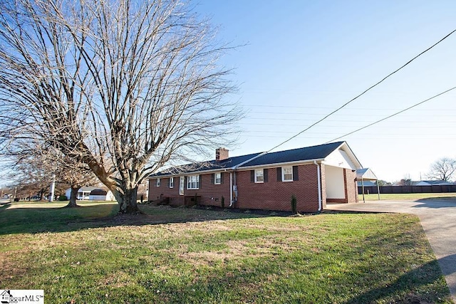 view of property exterior featuring a carport and a lawn