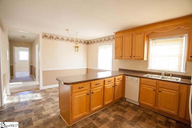 kitchen featuring a wealth of natural light, dishwasher, sink, kitchen peninsula, and pendant lighting