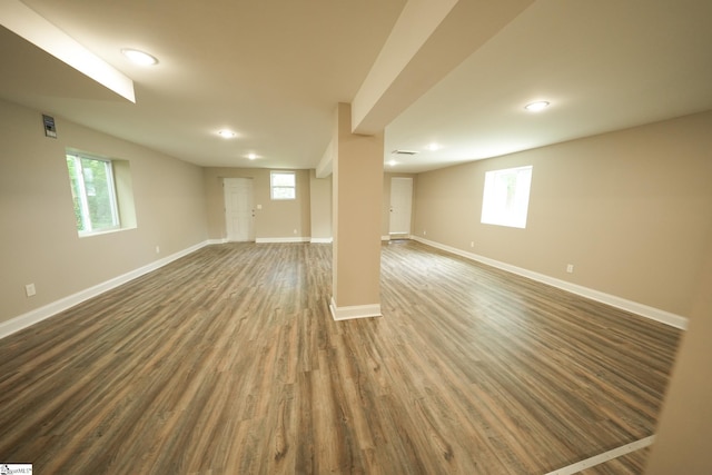 basement featuring a healthy amount of sunlight and dark wood-type flooring