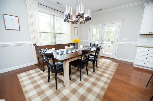 dining room featuring french doors, wood-type flooring, a notable chandelier, and ornamental molding