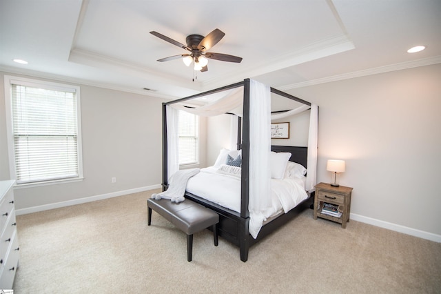 bedroom with light colored carpet, a raised ceiling, ceiling fan, crown molding, and multiple windows