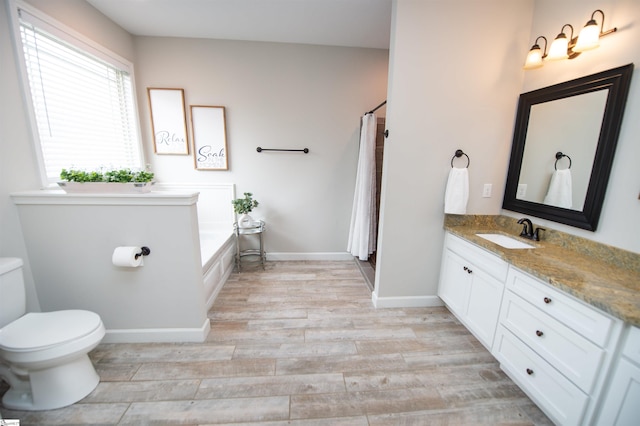 bathroom featuring a washtub, wood-type flooring, vanity, and toilet