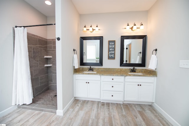 bathroom with a shower with shower curtain, wood-type flooring, and vanity