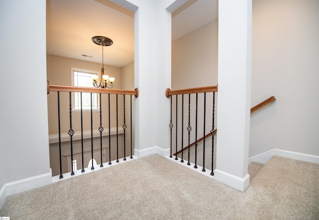 staircase with carpet floors and an inviting chandelier