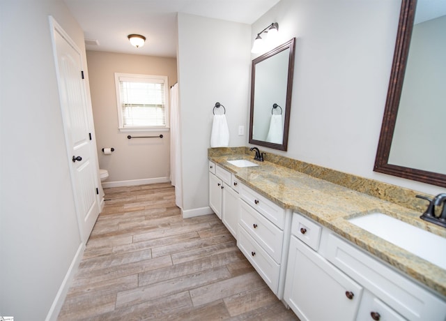 bathroom with toilet, vanity, and hardwood / wood-style flooring