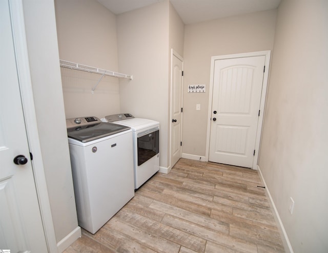 laundry room with washer and dryer and light hardwood / wood-style flooring